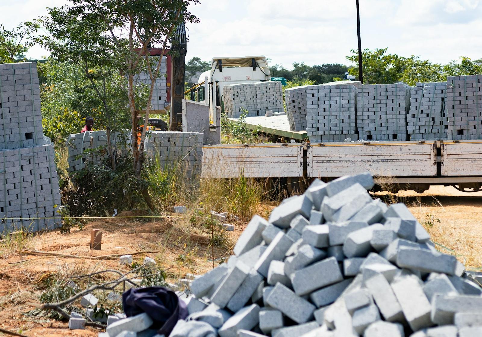 Concrete blocks stacked in bulk beside a flatbed delivery lorry